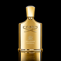A gold Creed Millesime Imperial perfume bottle with a faceted cap, set against a solid black background with a reflective gold surface below.