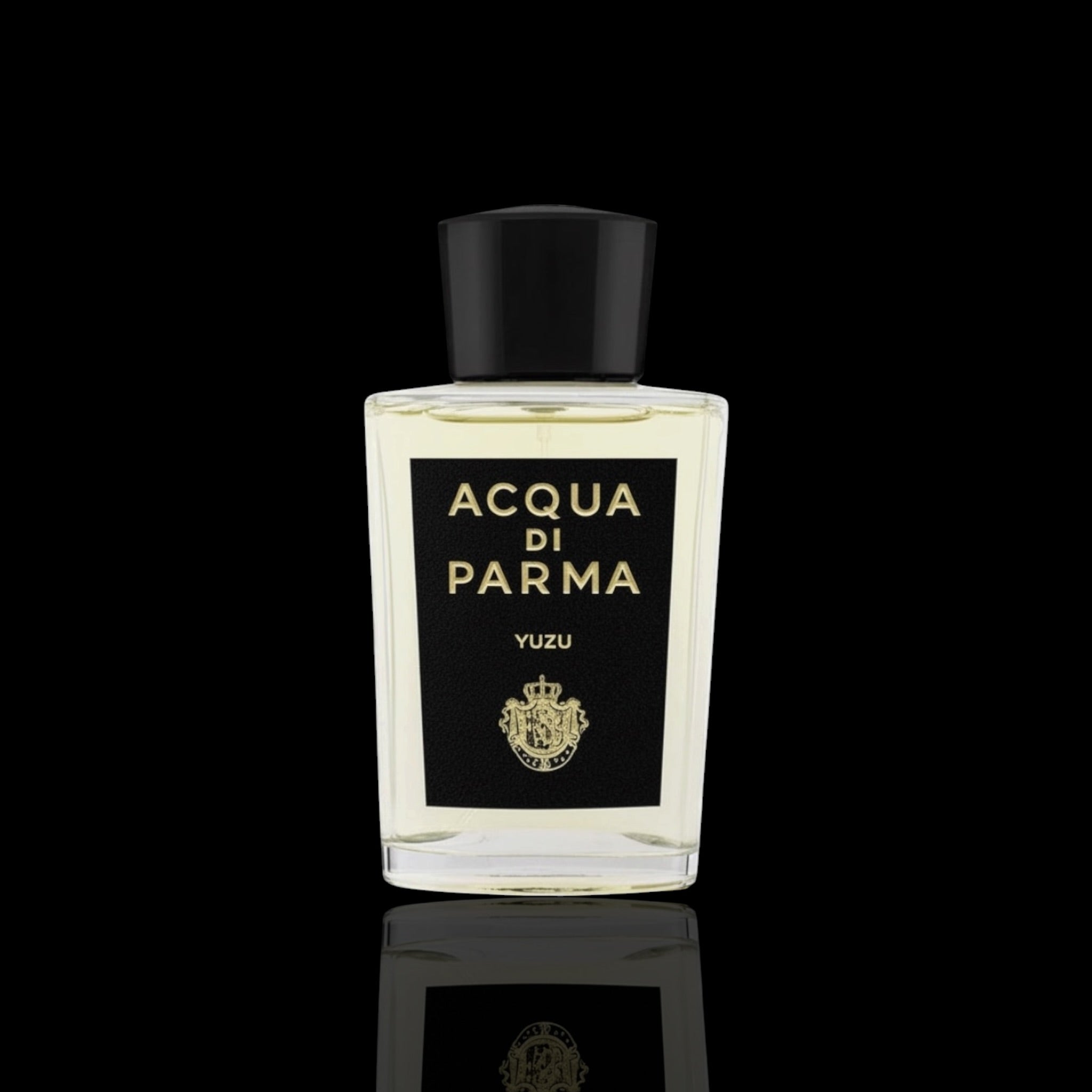 Acqua di Parma Yuzu bottle with clear glass, black label, and gold lettering on a black reflective background.