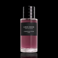 Dior Gris Dior Esprit de Parfum bottle with rose-colored fragrance and black label on a black reflective background.