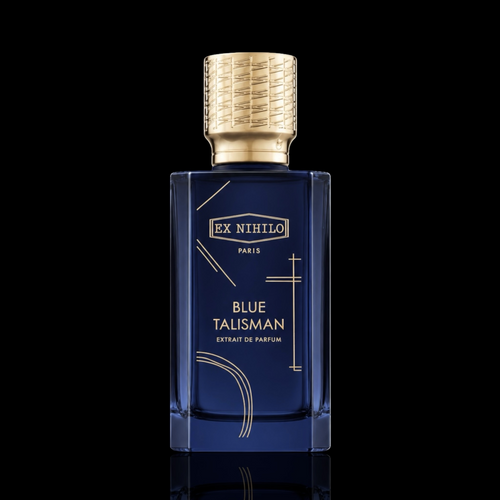 Ex Nihilo Blue Talisman Extrait de Parfum bottle with deep blue glass and gold accents on a black reflective background.
