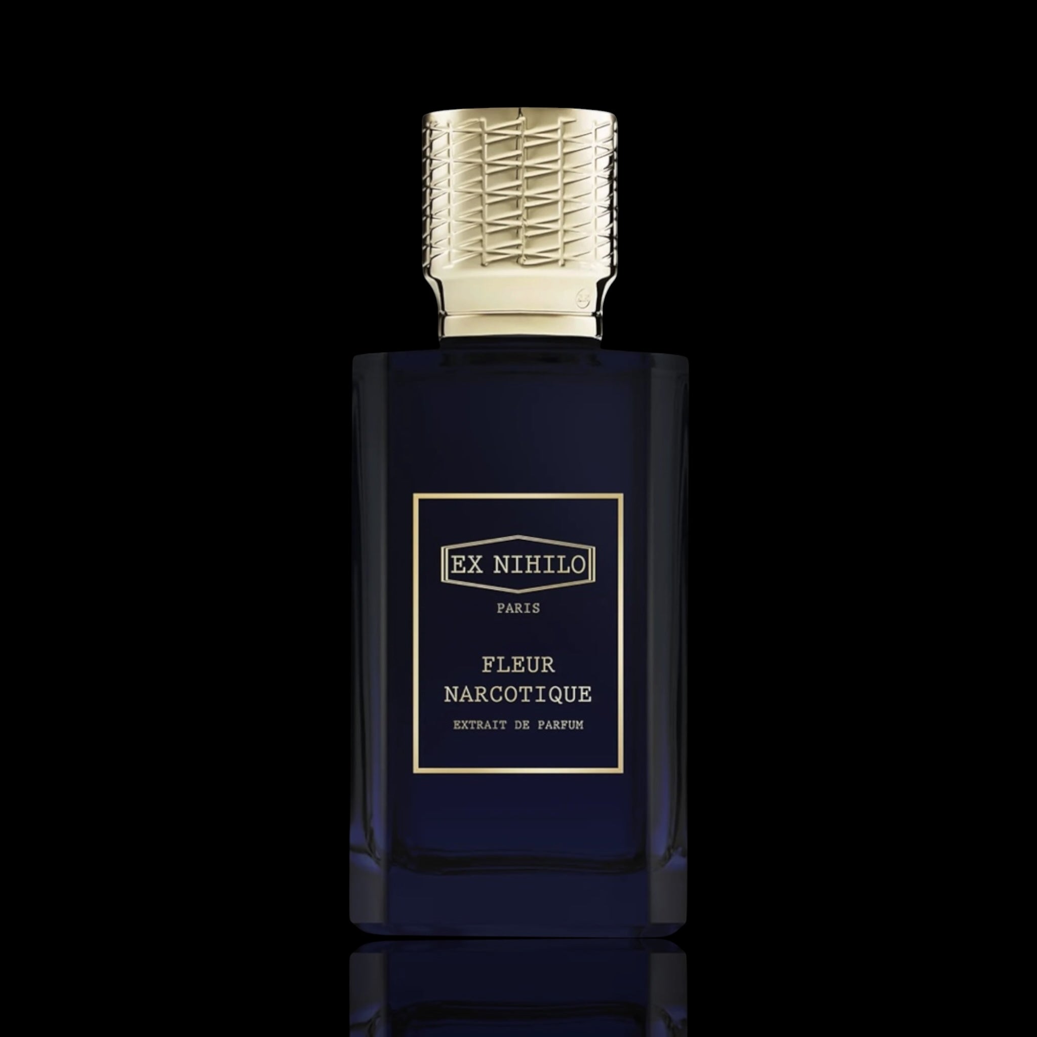 Ex Nihilo Fleur Narcotique Extrait de Parfum bottle with deep blue glass and gold accents on a black reflective background.