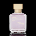 Maison Francis Kurkdjian Gentle Fluidity Gold bottle with soft pink glass and gold cap on a black reflective background.