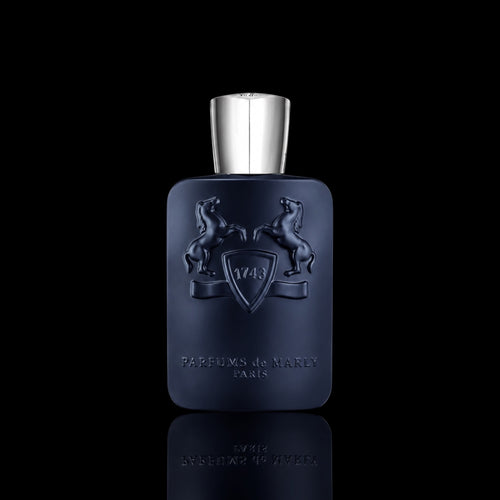 Parfums de Marly Layton bottle with deep navy blue finish and silver cap on a black reflective background.