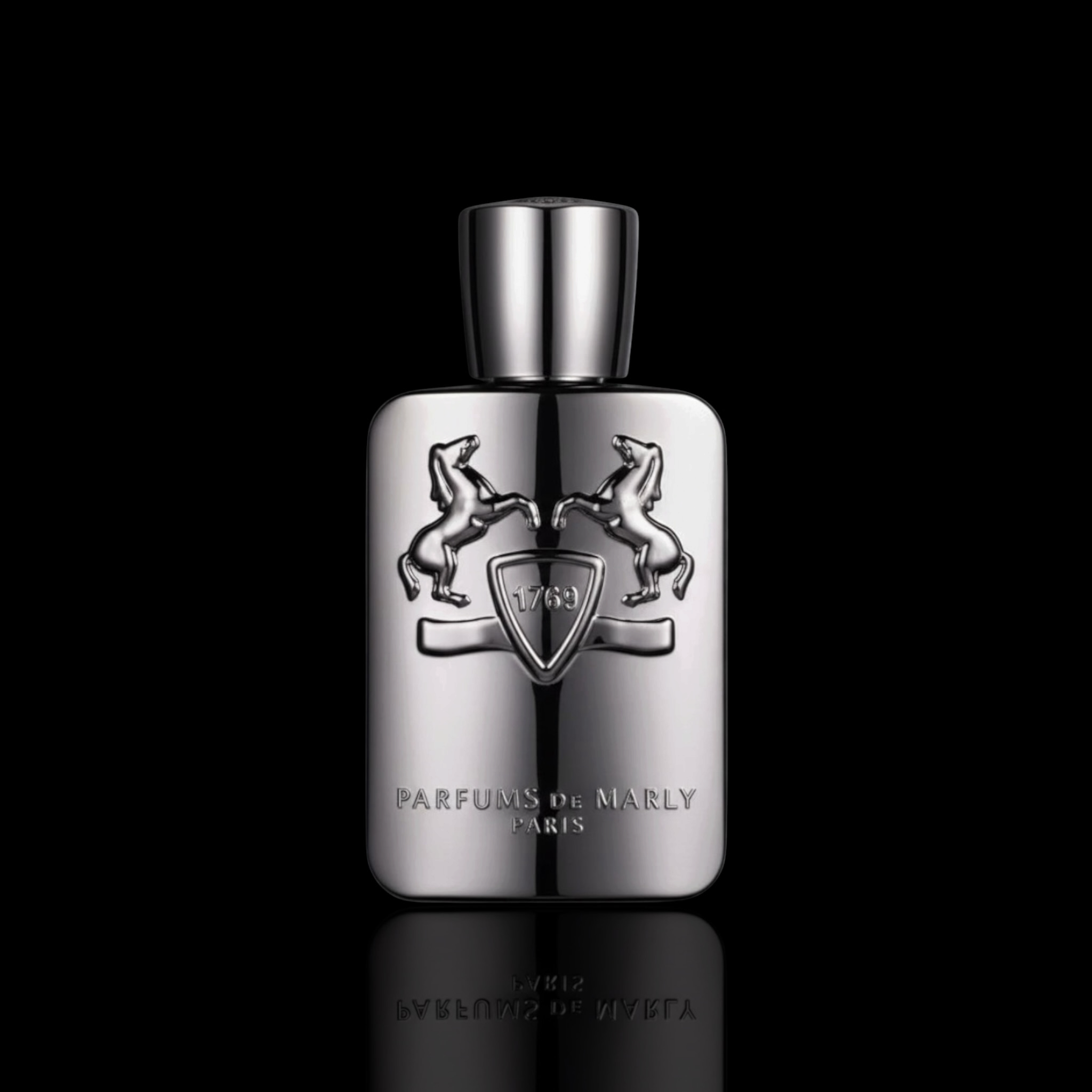 Parfums de Marly Pegasus bottle with metallic silver finish and black cap on a black reflective background.