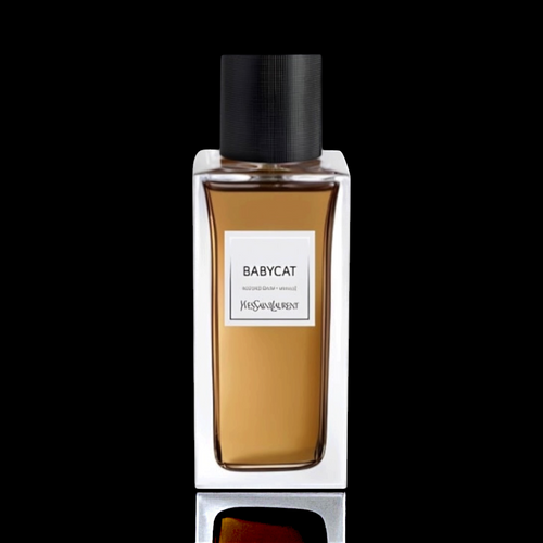 Yves Saint Laurent Babycat bottle with amber-colored fragrance and black cap on a black reflective background.