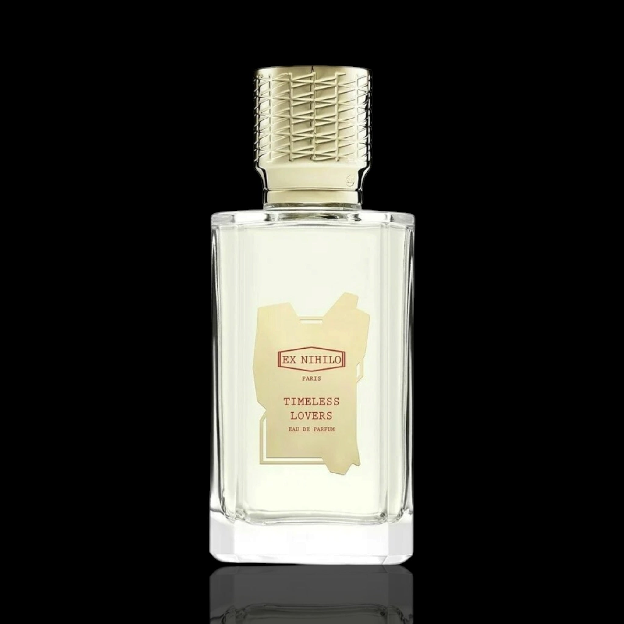 A bottle of Ex Menilo Paris 'Timeless Lovers' Eau de Parfum, featuring a clear glass bottle with a textured gold cap and a gold label, set against a solid black background.